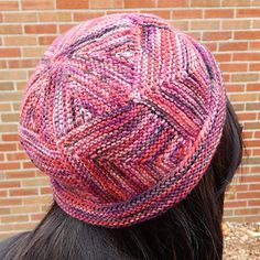 a close up of a person wearing a knitted hat on top of their head