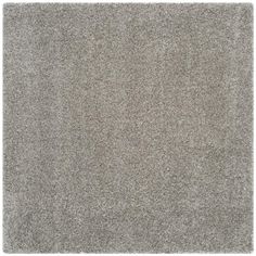 an area rug with grey carpeting on the floor