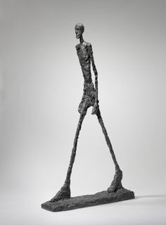 a sculpture of a man standing in front of a white background