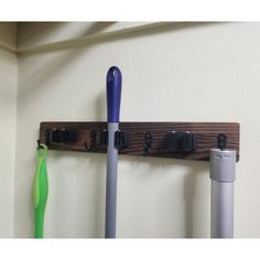 a coat rack with two umbrellas hanging from it's sides and one on the wall