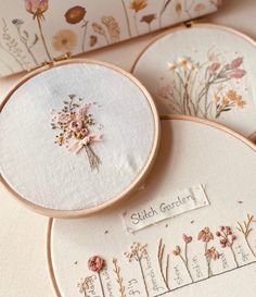 three embroidered hoops with flowers on them and the words stitch garden written in cursive writing