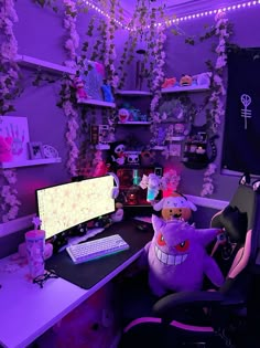 a desk with two computers and stuffed animals on it