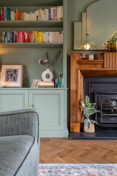 a living room filled with furniture and a fire place in front of a bookshelf