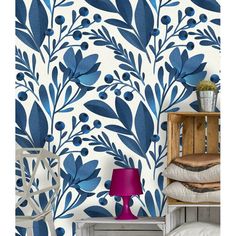 a blue and white floral wallpaper in a room with a chair, table and lamp