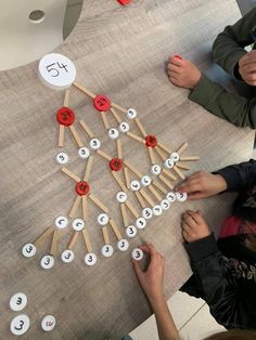 two children are making a christmas tree out of clothes pegs and wooden dows