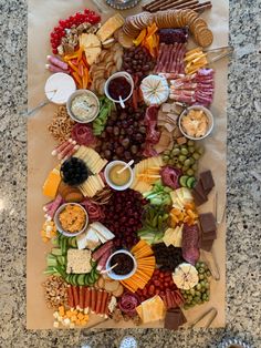 a large platter of cheeses, crackers, and meats on a cutting board