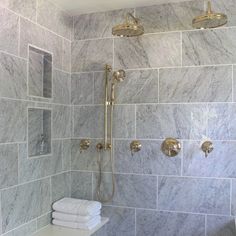 a white toilet sitting next to a walk in shower under a faucet mounted on the side of a wall