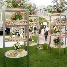 two people standing in front of an assortment of desserts on display at a wedding