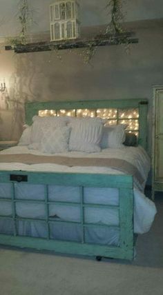 the bed frame is made from doors and has been painted green with white trims