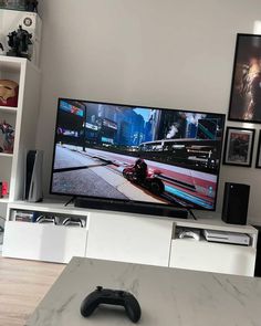 a flat screen tv sitting on top of a white entertainment center in a living room