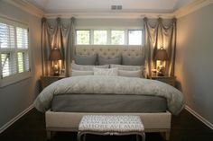 a large bed sitting in the middle of a bedroom next to two lamps on either side of it