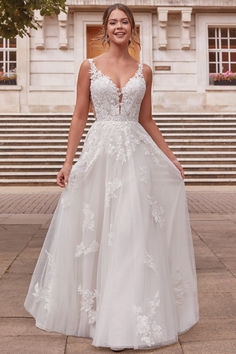 a woman in a white wedding dress standing outside