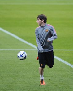 a young man kicking a soccer ball on a field