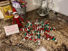 an elf is sitting on the counter next to some candy