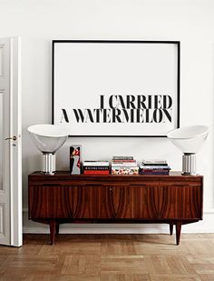 two white bowls sitting on top of a wooden table in front of a framed poster