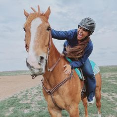 a woman riding on the back of a brown horse