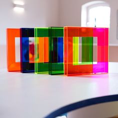 three different colored blocks sitting on top of a white table in front of a window