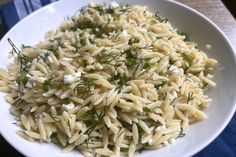 a white bowl filled with pasta and herbs