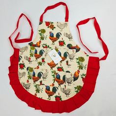 an apron with roosters on it and red straps