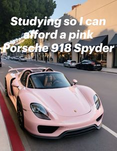 a pink porsche 918 spyder parked on the side of a road next to a building