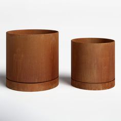 two wooden cups sitting next to each other on a white surface with no one around them