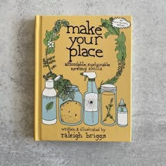 the book make your place is sitting on top of a gray surface with plants and jars