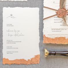 the wedding stationery is laid out on top of each other, including an ink pen