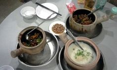 three pots and pans filled with food sitting on top of a table