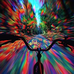 an image of a bike riding down the street with colorful lights on it's front wheel