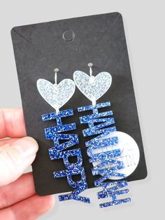 a pair of blue and white glittered earrings with the words happy new year written on them