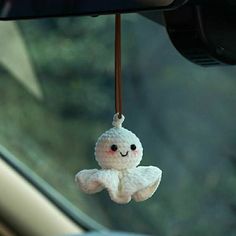 a white stuffed animal hanging from the side of a car