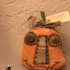 an orange stuffed animal hanging on the wall with a happy new year tag attached to it