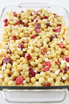 a casserole dish filled with corn kernels and cranberry toppings