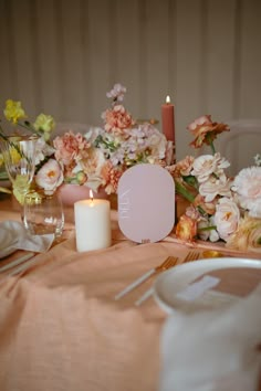 the table is set with flowers and candles