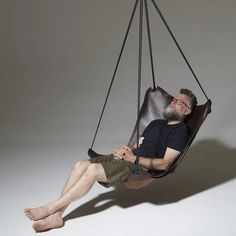 a man is sitting in a hammock chair