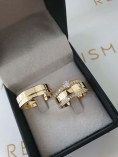 two gold rings with diamonds in a box