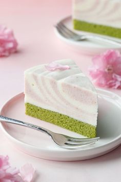 a piece of green cake on a plate with a fork and flowers in the background