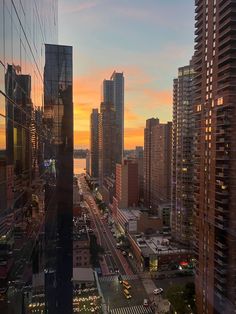 the sun is setting over a city with high rise buildings and skyscrapers in the foreground