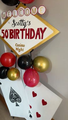 a casino themed birthday sign with balloons and cards