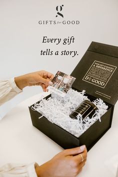 a woman is opening a black box with white shredded paper on it and the words, every gift tells a story