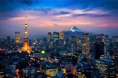 the tokyo skyline at night with mt fuji in the background