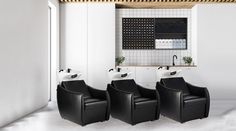 three black chairs sitting in front of a white wall with a sink and faucet