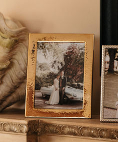 two framed photos are sitting on a mantle