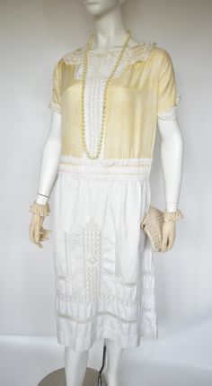 A lovely 1920's day dress with what appears to be a cream silk bodice embellished with lace collar and cuffs and wide cotton lace front panel. This contrasts with the white heavy cotton skirt with horizontal pleats around the waist interspersed with Lace banding.   Condition is very good.  There are some small marks throughout  including some light staining over the bodice. Some may improve with further careful laundering but I cannot guarantee it.  19" underarm to underarm measured flat  18.5 " waist measured flat  Please be aware that although the measurements are generous there is no fastening so has to fit over the head. it should fit a todays 12 if your shoulders are not too wide but please look at measurements. 1920s Day Dress, 1920s Dress, Cream Silk, Womens Robes, Lace Collar, Cotton Skirt, Day Dress, Collar And Cuff, Cotton Lace