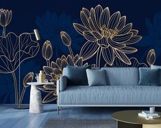 a living room with blue couches and gold flowers on the wall, along with a coffee table