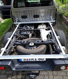 the back end of a pickup truck with its hood up and engine in it's bed