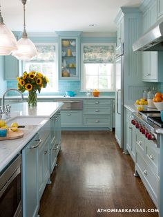 a kitchen filled with lots of blue cabinets and counter top space next to a stove top oven