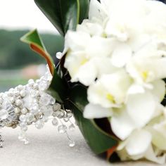 a bridal bouquet with white flowers and pearls