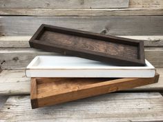 two wooden trays sitting on top of each other in front of wood planks