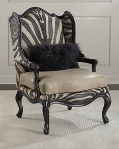 a zebra print chair with a black and white pillow on it's backrest